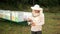 Man beekeeper in special clothes, holding a smoker to calm the bees