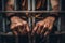 Man behind prison bars. Men\\\'s hands rest on the bars of a prison or prison cell. Conclusion concept. Crime and Punishment.