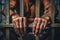 Man behind prison bars. Men\\\'s hands rest on the bars of a prison or prison cell. Conclusion concept. Crime and Punishment.