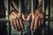 Man behind prison bars. Men\\\'s hands rest on the bars of a prison or prison cell. Conclusion concept. Crime and Punishment.