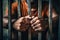 Man behind prison bars. Men\\\'s hands rest on the bars of a prison or prison cell. Conclusion concept. Crime and Punishment.