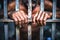 Man behind prison bars. Men\\\'s hands rest on the bars of a prison or prison cell. Conclusion concept. Crime and Punishment.