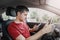 Man behind the wheel of car loses concentration on the road situation and gets stuck in a smartphone typing SMS in a chat.