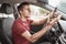 Man behind the wheel of car loses concentration on the road situation and gets stuck in a smartphone typing SMS in a chat.