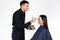 A man being a makeup artist holds a cosmetic palette, works to a female makeup on a white background