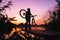 Man with a bicycle on the lookout admires the sunrise or sunset. Sport, active lifestyle. Beautiful colors at dawn