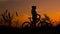 A man on a bicycle at sunset. A lonely man is training on a mountain bike in the evening. Cyclist on a mountain top enjoy