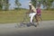 Man bicycling with woman on the back of the bike through the countryside of central Cuba