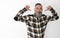 Man with big beard and mustache, plaid shirt raising arms and pointing to himself with funny face and direct gaze