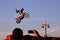 A man on bike jumps over the city.