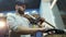 A man bike mechanic with a beard assembles a mountain bike in his workshop.