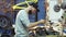 A man bike mechanic with a beard assembles a mountain bike in his workshop.