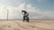 Man biker doing tire burnout in the desert, slow motion. Professional motorcyclist drifting on street bike on a dry salt