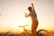 Man biker man meets a sunset in top of hill. He rising a one arm greeting on another successful day ending. Active sport people