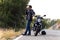 Man biker talking on the phone to the insurance of his motorcycle after having suffered a breakdown on the road