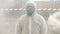 Man in bio-hazard suit and gas mask stands in the smoke