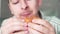 A man bites an unhealthy hamburger. Male mouth close-up, hungry man dines in office