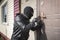 Man in a black balaclava mask opens a locked door with a lock pick. The robber breaks into the house. Robbery of a private house.