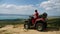 Man in a black cap and red t-shirt on a colored ATV rides