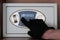 A man in black gloves enters a security code on the safe. The thief hacks electronic safe in the office or at home. Theft.