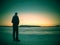 Man in black gray jacket on ice looking over frozen lake