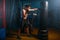 Man in black handwraps exercises with bag in gym