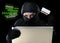 Man in black holding credit card using computer laptop for criminal activity hacking password and private information