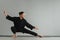 A man in black kimano practicing qigong energy exercises indoors