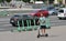 A man on a black scooter passes by a number of electric scooters in the city center