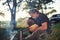 Man in black shirt near the campfire in the forest at his weekend time