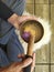 A man with a black shirt playing a tibetan bowl