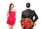 Man in black suit hiding flowers and woman