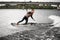 Man in black swimsuit rides through the waves on water board