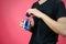 Man in black t shirt holding blue bottle toilet water. Close up, mock up. Isolated