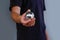 Man in black t-shirt holding Christmas toy ball silver.