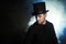 Man in a black top hat and cloak. Demonic image. Magician illusionist