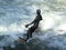 Man in black wetsuit is surfing in waves