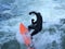 Man in black wetsuit is surfing in waves