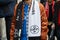 Man with black and white Off White scarf and bronze satin bomber jacket before Giorgio Armani fashion show,