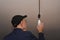 a man in a black work cap screws in a light bulb. installation of the LED lamp