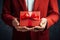 man in blazer and shirt holding gift red cardboard box