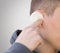 The man is bleeding from the ear. Earache. Close up. Isolated on a grey background