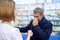 Man with blocked nose consulting with female pharmacist.