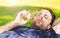 Man blowing soap bubbles while laying outdoor on grass