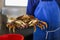 Man in blue apron holding big, living crab