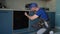 A man in a blue cap repairs an oven. Young Male Technician Repairing Oven In Kitchen