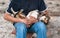 man in blue clothes sittting and holding brown dog