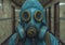 A man in the blue gas mask is standing in a hallway.