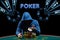 Man in blue hoodie showing aces, sitting at playing table with stacks of chips. Black background with neon dollar