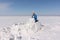 Man in a blue jacket building an igloo on a glade